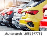 Back view many modern new multicolored SUV cars fleet stock dealership parking lot. Automobile market production factory industry warehouse. Auto salvage buy and sell auction purchase seller platform