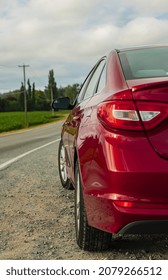 Back View Of Modern New Shiny Red Car Parked Outside Road In Countryside In A Cloudy Day. Transportation, Pollution And Ecology Concept. July 15,2021 Travel Photo, Nobody, Blurred, Langley BC, Canada