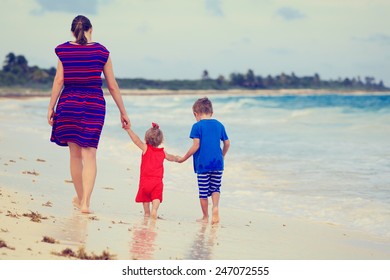 Back View Of Mother And Two Kids Walking On The Beach