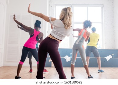 Back View Of Multiethnic Zumba Dancers Performing Movements In Dance Studio