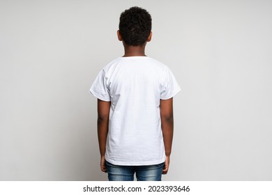 Back view of the multiracial boy wearing white T shirt. Childhood concept. Isolated on white background, studio shot