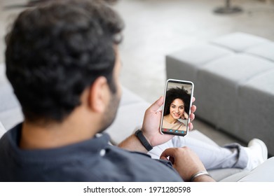 Back View Multiracial Middle-eastern Man Using Mobile Phone App For Video Meeting With Female Friend Or Employee, Guy Holds Smartphone, Talking Online With African Woman. Video Call