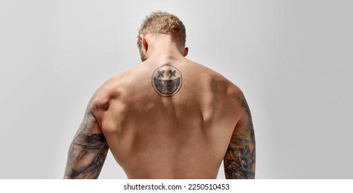 Back view of muscular strong man posing isolated over grey studio background. Man posing shirtless. Masculinity. Concept of men's health, beauty, body and skin care, fitness. Body art - Powered by Shutterstock