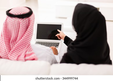 Back View Of Muslim Couple Pointing At Laptop Screen