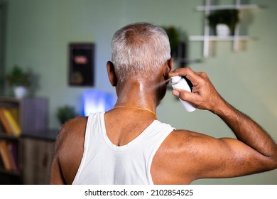 Back View Of Old Man Using Spray For Neck Pain Relief At Home - Neck Sprain,ache Treatment And Injuries Due To Aging