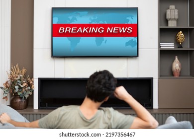 Back View On Excited Man Sitting On The Couch And Watching Breaking News On Tv At Home