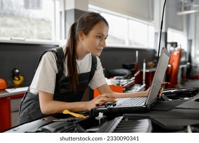 Back view on woman auto engineer doing computer diagnostic - Powered by Shutterstock