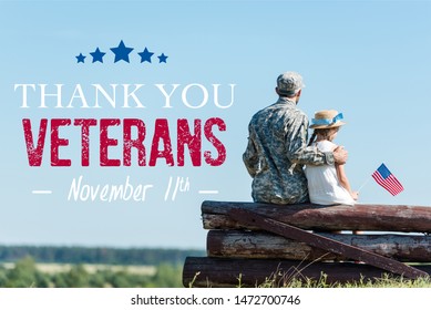 back view of patriotic child holding american flag near veteran father while sitting in fence with thank you veterans illustration
