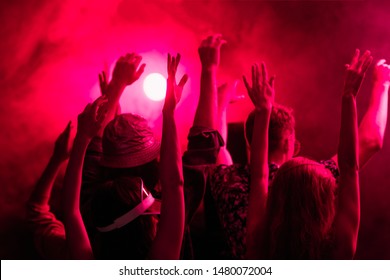 Back View Of People With Raised Hands During Rave Party In Nightclub