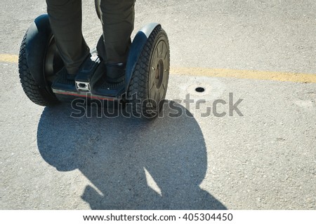 Back view of person using segway. Sunny outdoors background