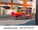 Back view photo of rickshaws parked in front of Klewer Market, Surakarta, Indonesia in the morning.