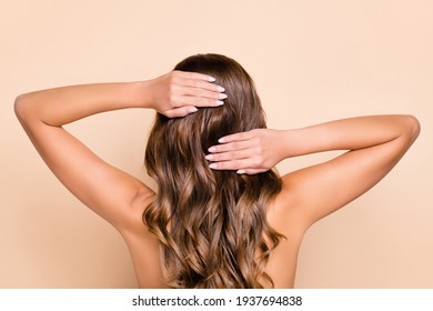 Back View Photo Of Young Beautiful Woman Washing Wavy Brown Hair With Shampoo Isolated On Beige Color Background