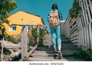 back view photo of young beauty woman backpacker walking on wooden walkway stairs preparing going to travel hotel check in during summer vacation holiday.