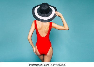 Back View Photo Of Young Slim Woman In Big Hat And Red Swimsuit Over Blue Background 