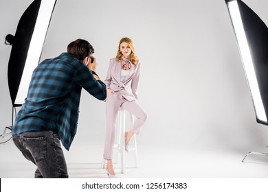 back view of photographer shooting beautiful young female model in studio - Powered by Shutterstock