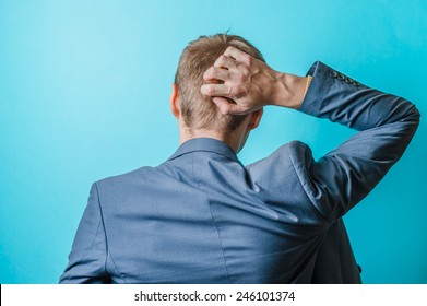 Back View Picture Of A Young Business Man Scratching His Head 