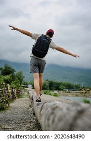 Back view point of young man walking on the log and attempt to balance himself , freedom , motivation and recreation concept