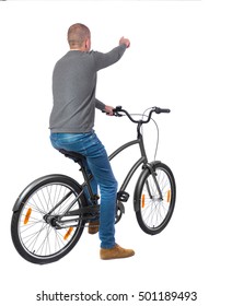 Back View Of Pointing Man With A Bicycle. Cyclist Sits On The Bike.  Rear View People Collection.  Backside View Of Person. Isolated Over White Background.