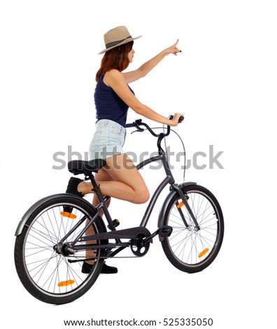 back view of pointing woman with a bicycle. cyclist sits on the bike. Rear view people collection.  backside view of person. Isolated over white background. Girl cyclist is crossing his frame.