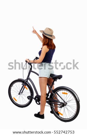 back view of pointing woman with a bicycle. cyclist sits on bike. Rear view people collection. backside view of person. Isolated over white background. Girl cyclist in summer clothes shows thumb up