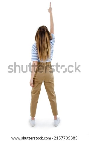 Back view of pointing young women in trousers and striped T-shirt. Young girl gestures. Rear view people collection, backside view of person. Isolated on white background. Studio shot