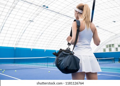 Back view portrait of beautiful blonde woman entering tennis court for practice, copy space - Powered by Shutterstock