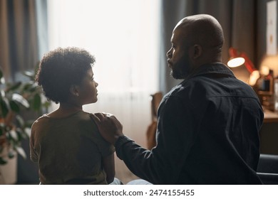 Back view portrait of caring single father comforting young son sitting on bed together against window light - Powered by Shutterstock