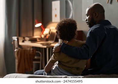 Back view portrait of caring single father embracing son sitting on bed together and talking copy space - Powered by Shutterstock