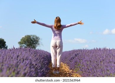 Back View Portrait Of A Casual Woman Outstretching Arms Celebrating In Lavender Field