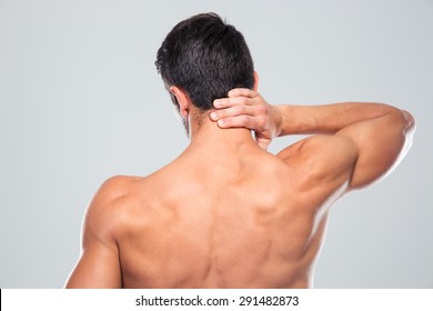 Back View Portrait Of A Man With Neck Pain Over Gray Background