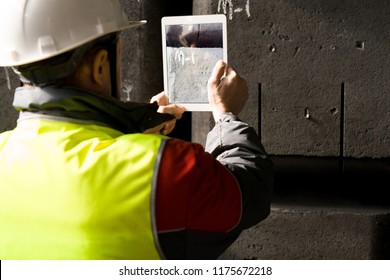 Back view portrait of modern factory worker wearing hardhat taking photo of codes while using digital tablet, copy space - Powered by Shutterstock