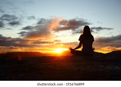 Back View Portrait Of A Woman Silhouette Doing Yoga At Sunset In The Mountain