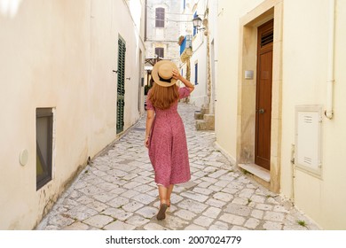 Back view of pretty tourist woman walking in narrow alley of typical old town of Italy - Shutterstock ID 2007024779