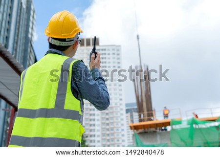 back view of professional engineer asian male safety helmet manage control constuction site with expertise working