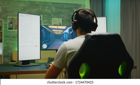 Back View Of Professional Gamer Streaming His Competition On Triple Monitor Setup With Two Streaming Chats Open