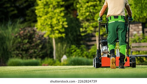 Back View of Professional Gardener Mowing the Backyard Lawn with Push Mower. Garden Care and Maintenance Theme. - Shutterstock ID 2262824739