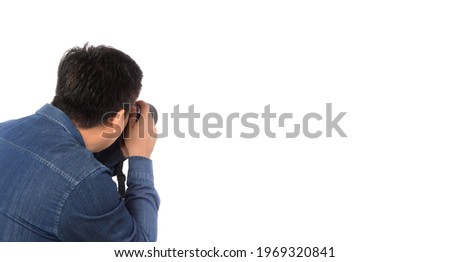 Back view professional photographer holding camera working. Photography in action in studio over white background, Free from copy space.