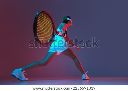 Back view of professional tennis player playing tennis over pink-purple background in neon light. Concept of sport, health, strength, action, motion, lifestyle. Copy space for ad