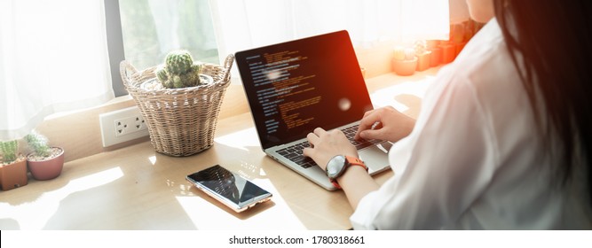 Back view of Programer Woman hands typing source code html and programming on screen laptop,development program,web design,developer abap,sap in cafe.New normal of freelance work process concept.