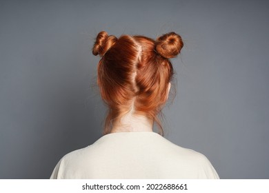 back view of red-haired woman with space buns hairstyle - Powered by Shutterstock