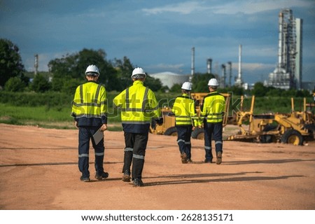 Back view refinery process engineer team working outdoor at petrochemical oil and gas industrial production plant, group of crude oil team working on site checking impact on environment, 