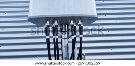 Back view of rooftop cellular antenna with coax jumpers and connectors, modern mobile network hardware.