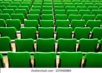 Back View Row Of Green Numbered Folding Seats In Sports Complex Indoor Stadium Arena. Seating Area In Event Hall. Abstract Beautiful Background Texture.