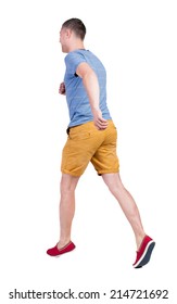 Back View Of Running Man In T-shirt And Shorts. Walking Guy In Motion. Rear View People Collection. Backside View Of Person. Isolated Over White Background.