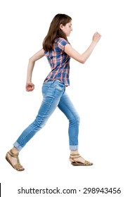 Back View Running  Woman In Jeans. Beautiful Blonde Girl In Motion. Backside View Of Person.  Isolated Over White Background. A Young Girl In A Checkered Blue With Red Stripes Running Waving His Arms