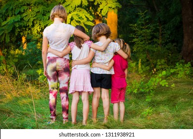 Back View Of Sad Children Stand In Hug Together In Summer