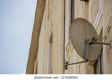 Back view of a satellite dish antenna installed on the exterior wall of a construction