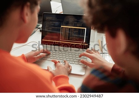 Back view at schoolchildren using laptop in computer programming class for kids at school