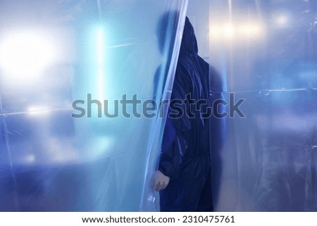 Back view of scientist or medical worker wearing full protective suit entering biohazard danger zone, copy space
