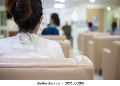 Back View And Selective Focus With Copy Space Of Asian Woman Wearing Doctor Mask Is Waiting For Doctor In Hospital Lobby For Health Diagnostic. She Feel Lonely And Worry About Her Symptoms.